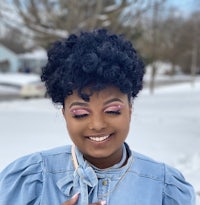 a black woman wearing a denim shirt and pink lipstick